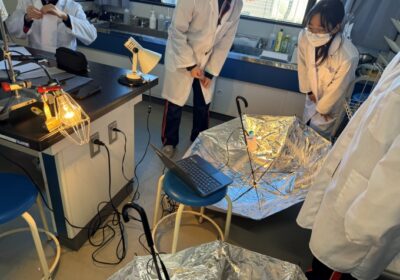Students investigating the thermal efficiency of a solar oven using a parabolic reflector.