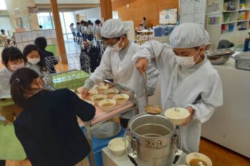 5年生：低学年の子ども達を手伝っています。　Grade 5: Taking care of the lower grade students.